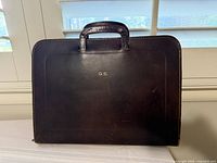 Front of dark brown leather briefcase with gold monogram G.S.