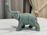 left side view of glossy teal porcelain elephant