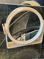 Front view of round plastic tabletop mirror showing reflective surface and frame