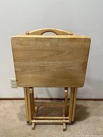 front view of two wooden folding TV trays set in matching wooden stand