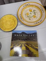 Dinner plate, salad plate, and Napa Valley book on tabletop