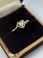 Front angle view of silver heart diamond ring in box
