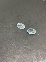 Two oval aquamarines on dark background