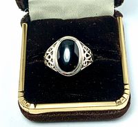 Top view of sterling silver ring with black onyx set in oval bezel inside box