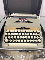 Typewriter in open carry case showing keyboard and body