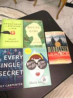 Five softcover novels laid out