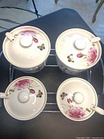 top view of four ceramic jars with lids on metal stand