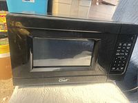 Front view of black Master Chef microwave showing control panel and window