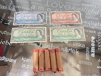 Overview of four Canadian bills and five penny rolls