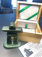 Jade inuksuk, open presentation box, leaflet visible