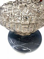 Close view of silver cityscape detail and marble base