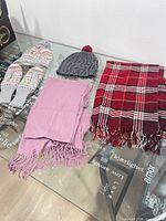 Overview of both hats, mittens, pink scarf and red plaid scarf