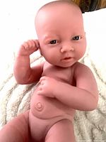 Front view of full vinyl newborn doll showing facial features, torso, limbs