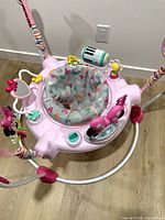 Top view of pink Minnie Mouse activity jumper showing seat and attached toys