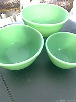 Three mint green glass nesting bowls upright