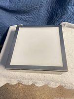 Top view of square flush mount light showing frosted glass centre and brushed metal border