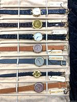 All seven watches secured in velvet roll, showing variety of straps and dials