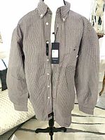 Full front view of Tommy Hilfiger plaid shirt on hanger showing overall design and tags