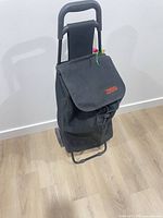 Front view of black fabric rolling cart with flap closed