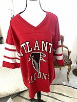 Front view on mannequin showing full shirt, V-neck, sleeve stripes