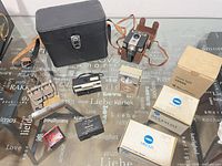 Overview of all items on table including cameras, splicer, viewer, Minolta boxed items, Pentax clip and case