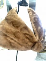Front view of brown fur shoulder cape displayed on dress form