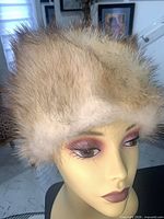 Front view of beige-brown fur hat on mannequin head