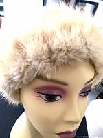 Front view of light beige fur hat on mannequin head