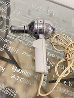 Side view of chrome Wigo Taifun hairdryer with handle and cord