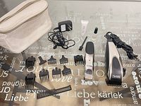 Entire kit laid out: clipper, trimmer, guards, comb, brush, oil, charger, pouch