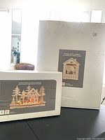 Two sealed boxes containing the wooden advent calendar and chalet