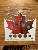 Front view of sealed maple-leaf coin set showing all 12 coins