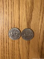 Both coins reverse side showing voyageur canoe design