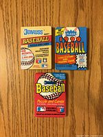 Front view of three sealed baseball card packs showing brand and series