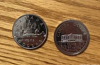 1972 and 1973 Canada dollars reverse sides showing Voyageur canoe scene and Province House design