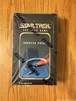 Front of sealed Star Trek The Card Game booster box showing title and artwork