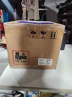 Sealed cardboard carton, exterior shipping symbols visible