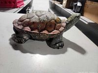 Side view of concrete turtle showing shell paint wear