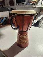 Full view of djembe front showing carved shell, rope tuning and overall condition