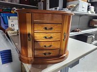 Front view showing wood finish, four drawers, curved sides