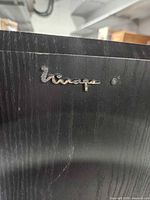 Mirage logo badge on black wood-grain cabinet corner