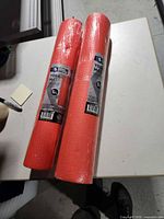 Two sealed orange yoga mats with labels visible
