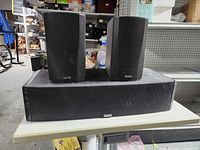 Two Micro130x satellite speakers and one center channel speaker on table