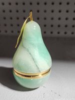 Green alabaster pear trinket box front view showing gold-tone stem, leaf and hinge