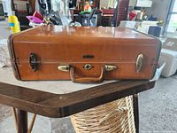 Front of brown Samsonite suitcase showing handle, badge and latches