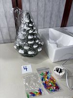 Tree wrapped in plastic with cord, bulb bags and styrofoam insert visible