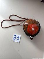 Front view of coconut shell purse showing flower design and strap