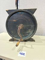 Side view of tabletop barrel butter churn with crank handle