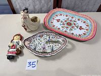 Group shot of all four items: Portuguese platter, plastic platter, lady planter, Cyprus ornament