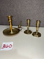 All three brass candle holders displayed